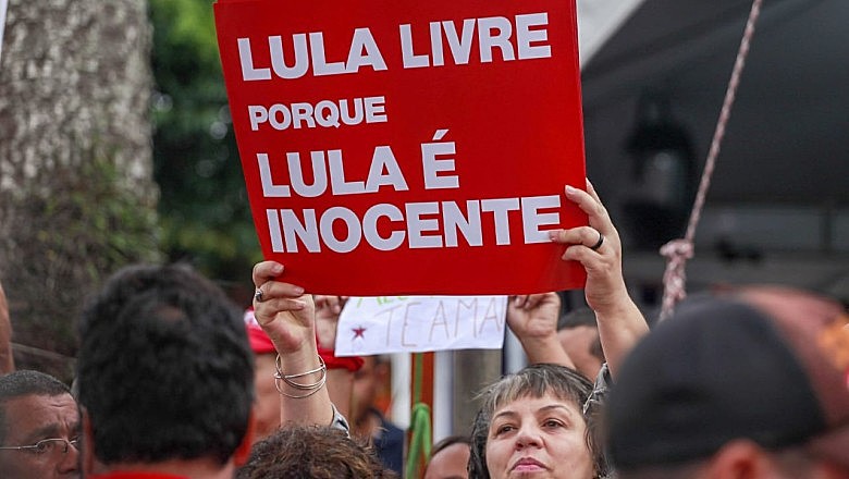 Cartaz reafirma inocência do ex-presidente Lula durante Caravana Lula Livre em Curitiba (PR). Sítio atribuído ao petista será vendido.