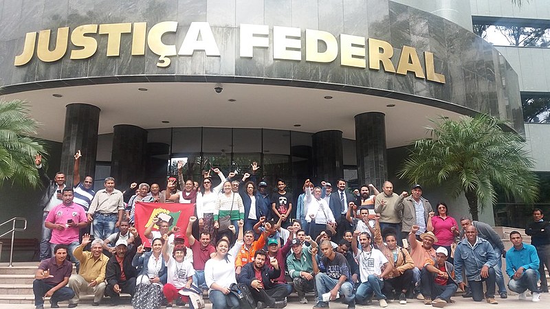 Comunidade posa em frente à 11ª Vara Federal de Curitiba, após audiência de conciliação.
