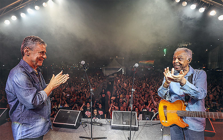 Chico aplaude Gil que aplaude Chico após apresentação do Festival Lula Livre em nos Arcos da Lapa, ano passado