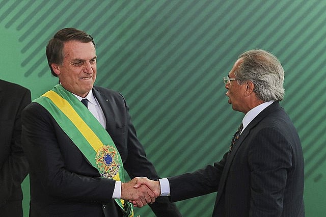 Brazilian president Jair Bolsonaro (right) shakes hands with his economy minister and author of pension reform draft proposal, Paulo Guedes