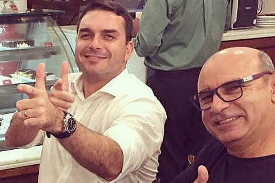Flávio Bolsonaro e Fabricio Queiroz fazem o gesto da "arminha", uma das marcas da campanha presidencial do PSL em 2018
