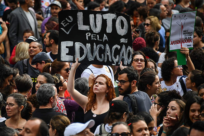 Mulher segura placa de protesto durante o Tsunami pela Educação, dia 15 de maio