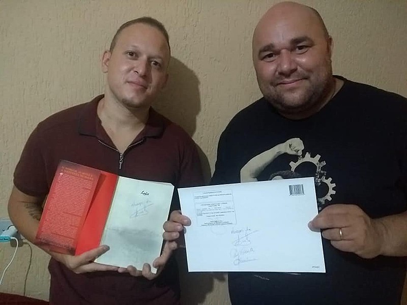 Antonio Elandio (dir.) posa com o diploma ao lado do primo