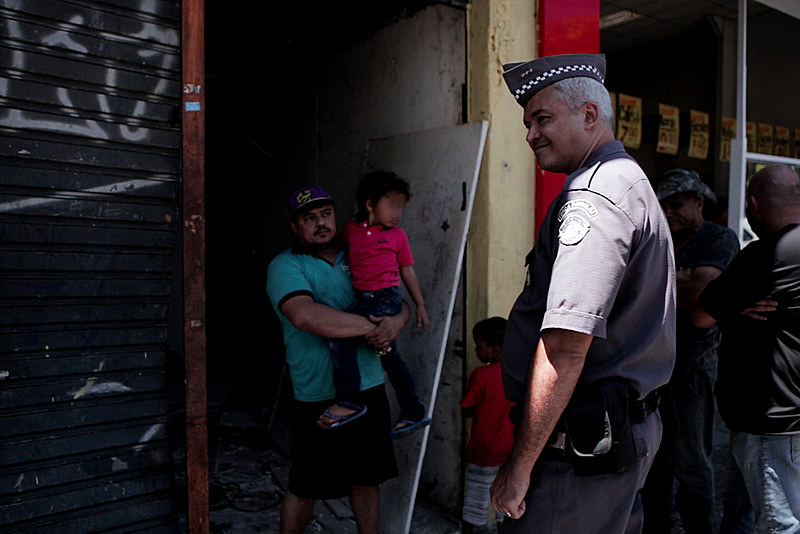 Policial sorri em frente ao cortiço onde moravam 40 famílias, na região da Luz. Imóvel foi desocupado sem auxílio de órgãos municipais
