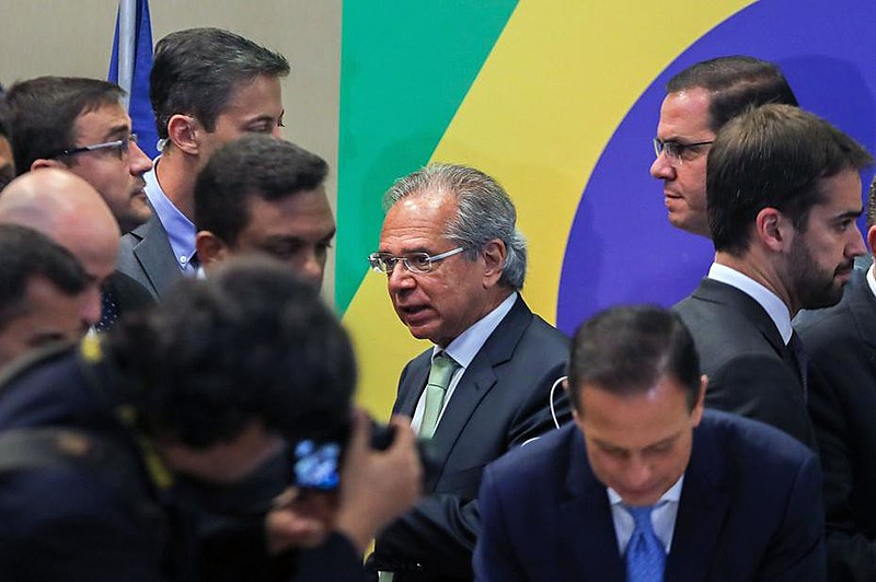 Ministro da Economia de Bolsonaro, Paulo Guedes [centro] aposta em modelo que deu errado