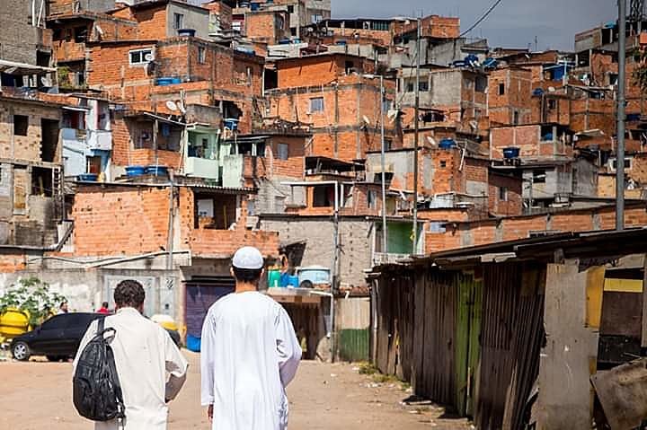 Jovem muçulmano caminha na entrada da favela Cultura Física, em Embu das Artes (SP)
