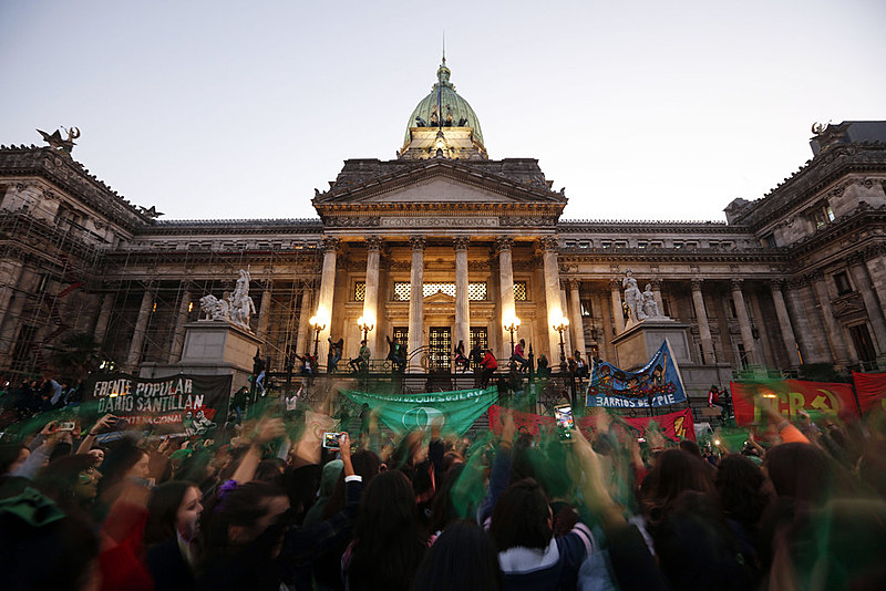 Manifestantes levantam seus lenços verdes, símbolo da campanha pelo aborto legal, em frente ao Congresso argentino