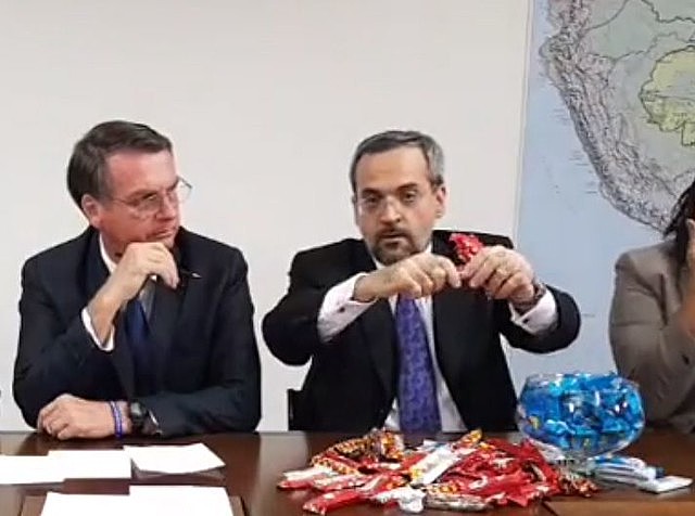 Jair Bolsonaro (left) and Education minister Abraham Weintraub trying to explain education budget cuts using chocolate bars