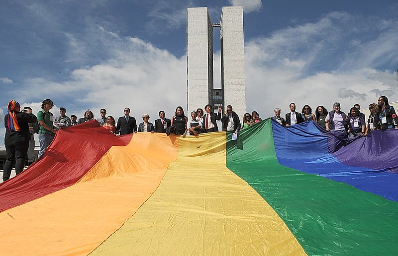 Ativistas LGBTs seguram bandeira arco íris na frente do Congresso Nacional durante a primeira Marcha Contra a Homofobia