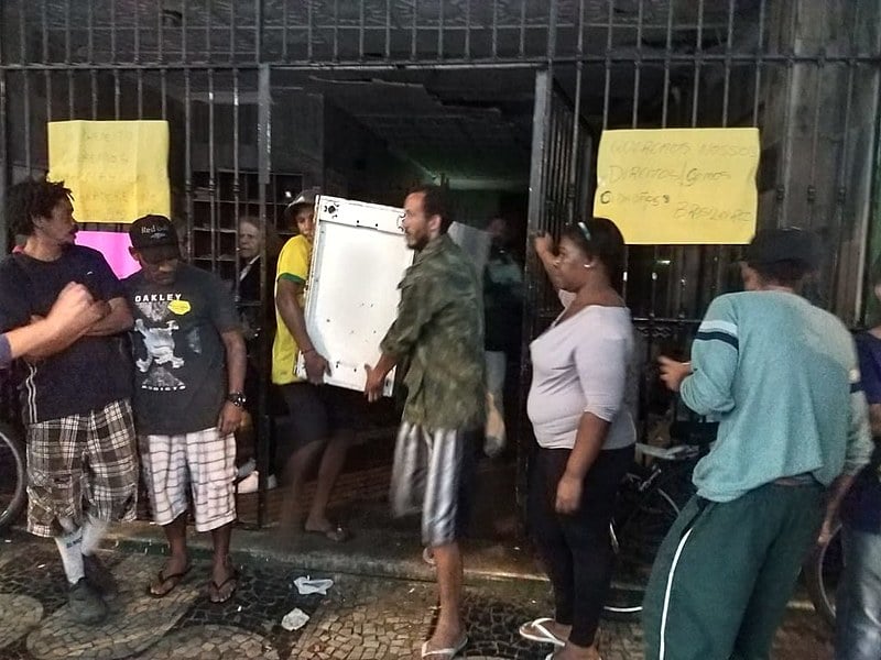 Pela calçada em frente ao edifício, armários, colchões, geladeiras e sacos pretos reúnem os pertences pessoais dos mais de 50 moradores