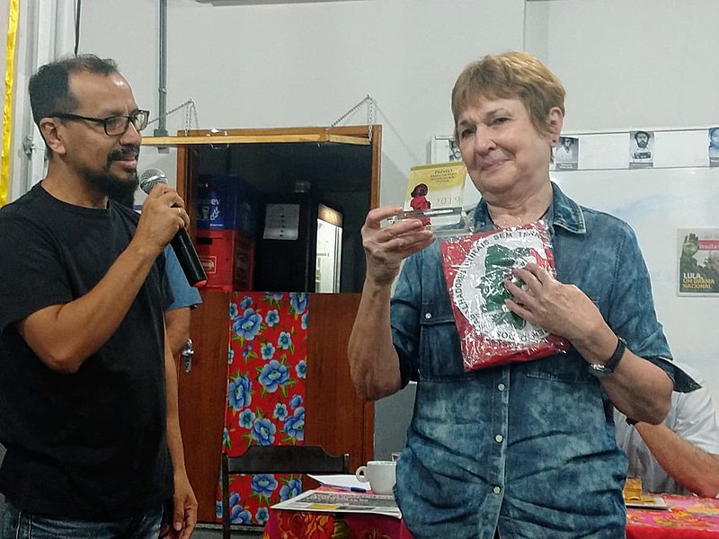 Elza Moraes, viúva de Mario Augusto, recebe o prêmio Brasil de Fato das mãos de Joaquín Piñero do MST, conselheiro da sucursal do Rio