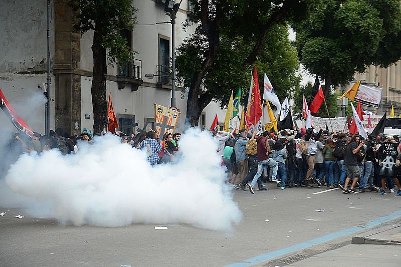 Momento em que polícia alveja bombas de gás contra manifestantes que criticavam mudanças no INSS e na CLT