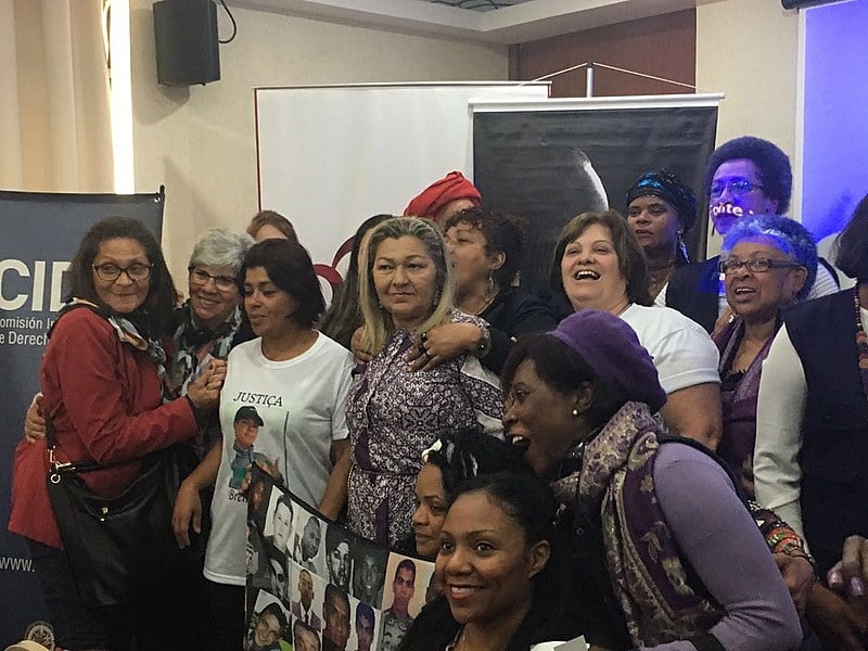 Mães de Maio, Mães Mogianas e outras militantes contra a violência contra mulheres negras tiram foto com relatora de Direitos de Afrodescendentes e Mulheres da OEA, Margarette Macaulay