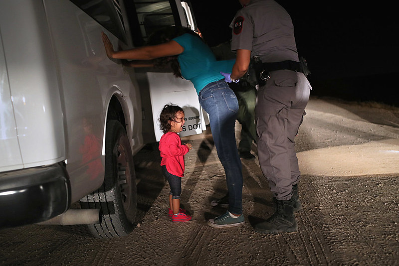 Imagem de criança chorando ao ver sua mãe ser revistada por uma agente de segurança dos EUA se tornou símbolo da perversa política de Trump