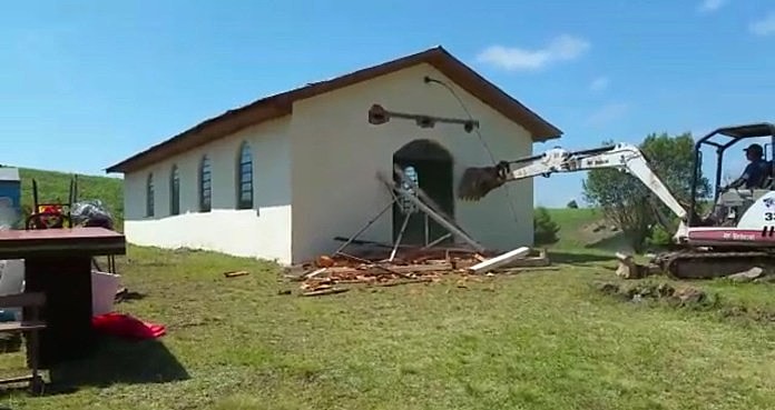 Momento em que as máquinas destroem a igreja da comunidade