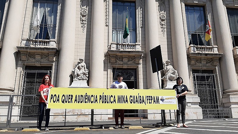 Ativistas do Comitê seguram faixa em frente ao Palácio Piratini, ao lado da Assembleia Legislativa