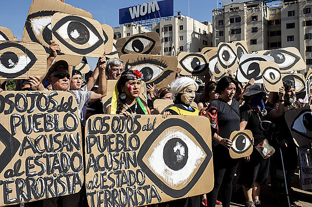 Chilenos exibem cartazes em referência aos projéteis que atingem os olhos dos manifestantes durante um protesto em dezembro