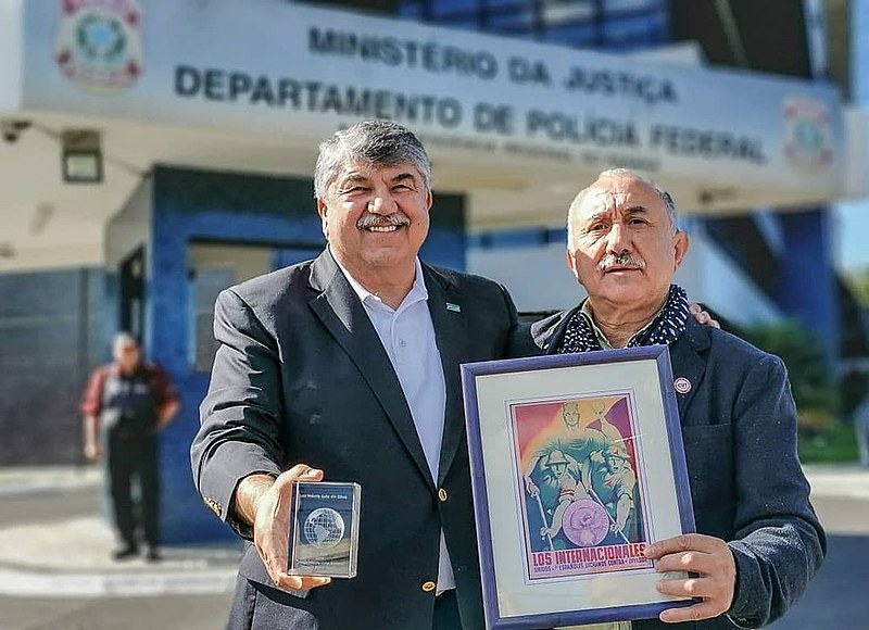 Richard Trumka e Pepe Alvarez, líderes de sindicatos norte-americano e espanhol levam prêmio de Direitos Humanos, em mãos, ao ex-presidente.