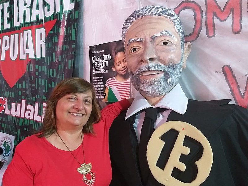 Valente (esq.) posa ao lado de boneco do ex-presidente Lula em Curitiba (PR)