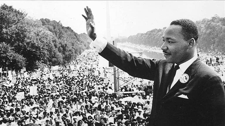 O reverendo Martin Luther King acena ao público presente na Marcha em Washington por direitos civis para negros e negras