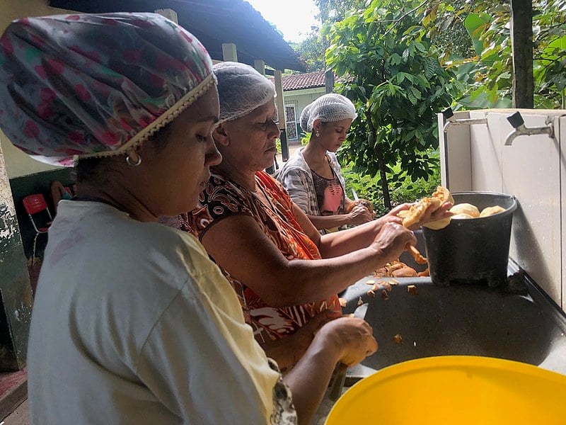 Grupo de mulheres fazem o doce de jenipapo.