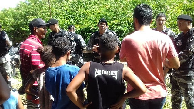 Policiais negociando com a população através de muita tensão.