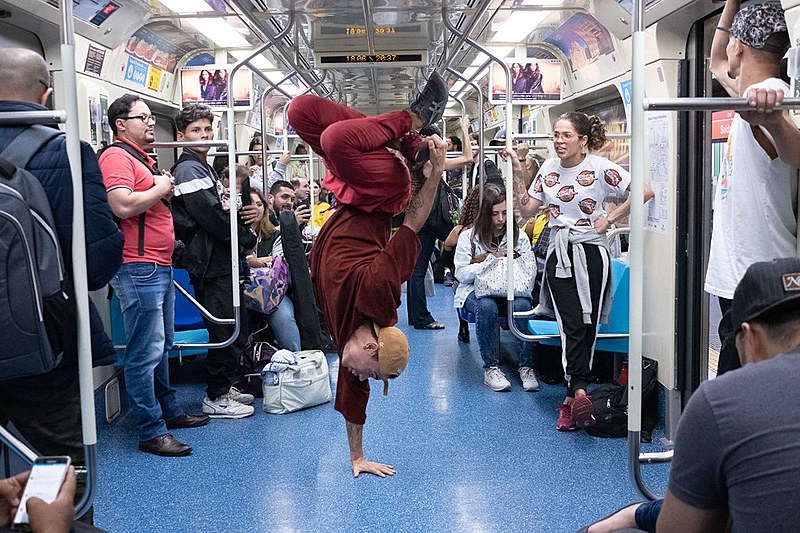 Mesmo com o trem em movimento, dançarinos de hip hop se apresentam em meio aos passageiros