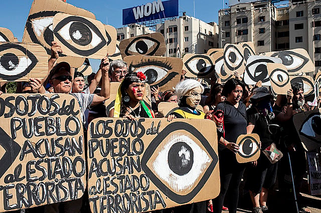 Chilenos exibem cartazes em referência aos projéteis que atingem os olhos dos manifestantes durante um protesto em dezembro