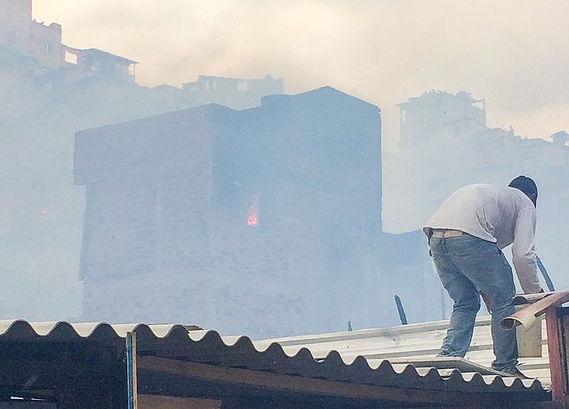 Morador tenta combater o fogo na favela de Paraisópolis