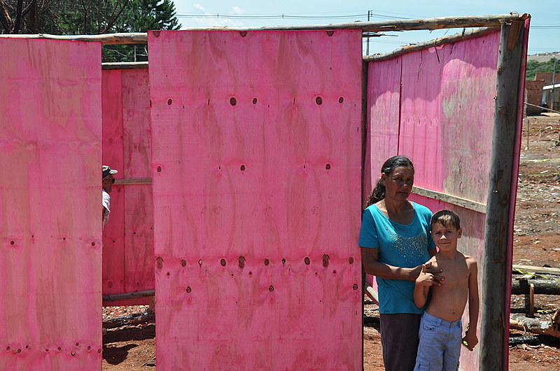 Dona Rosa, com o neto, na casa que está sendo construída: "Me sinto muito feliz."