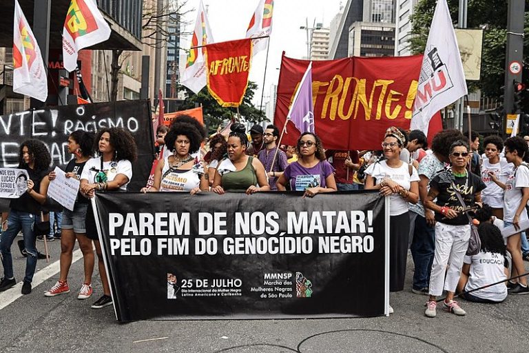 Marchers hold banner that reads "Stop killing us! For the end of black genocide" during demonstration in São Paulo on Nov. 20