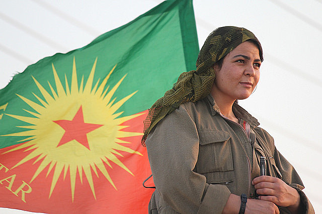 Kurdish fighter with PKK flag; taking down the patriarchy is crucial for the party to end the war