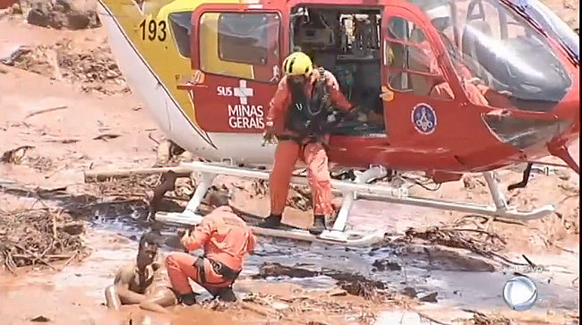 Socorristas trabalham no resgate de vítimas do mar de lama tóxica.