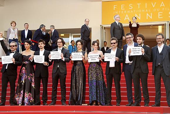 Equipe do filme Aquarius, dirigido pelo brasileiro Kleber Mendonça Filho, protestam no tapete vermelho do Festival de Cinema de Cannes