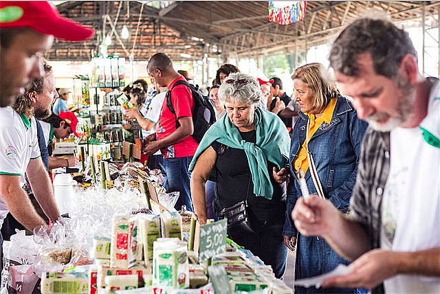 Consumidores de la Feria Nacional de Reforma Agraria examinan arroz orgánico de cooperativas de Rio Grande do Sul