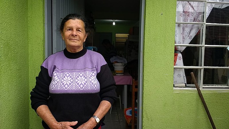 Enoemim posa em frente à casa em que mora hoje, mas não se esquece do antigo lar