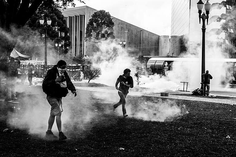Polícia lançava gás lacrimogêneo, bombas de efeito moral, balas de borracha contra educadores e educandos do Paraná.