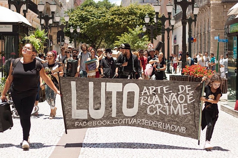 O Palhaço Chameguinho, que atua há 30 anos nas ruas, está acorrentado há mais de 15 dias na Rua XV como forma de protesto.  