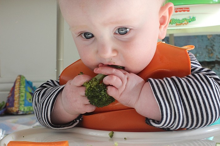Criança comendo brócolis