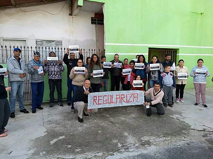 Moradores segurando cartazes e faixas durante o protesto realizado no dia 18 de maio