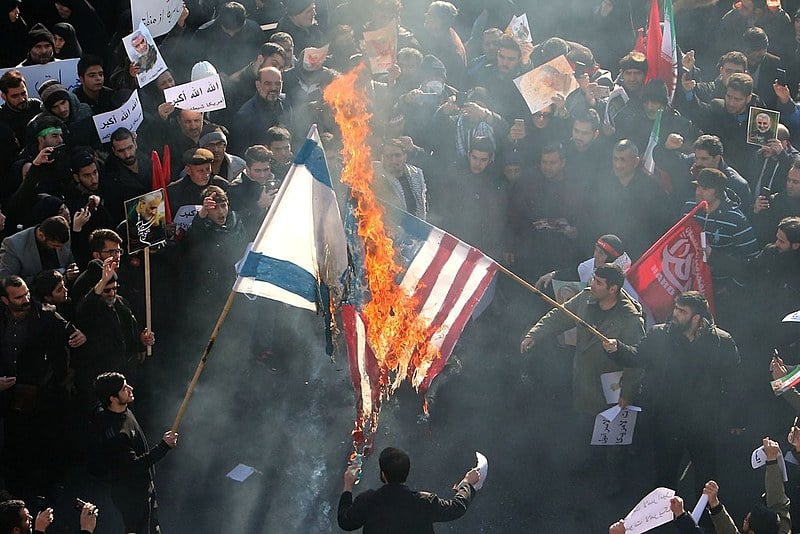Manifestantes iranianos queimam as bandeiras dos Estados Unidos e de Israel, em Teerã
