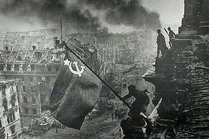 Soldado hasteia bandeira soviética no telhado do Reichstag, a sede do Parlamento alemão, em 9 de maio de 1945