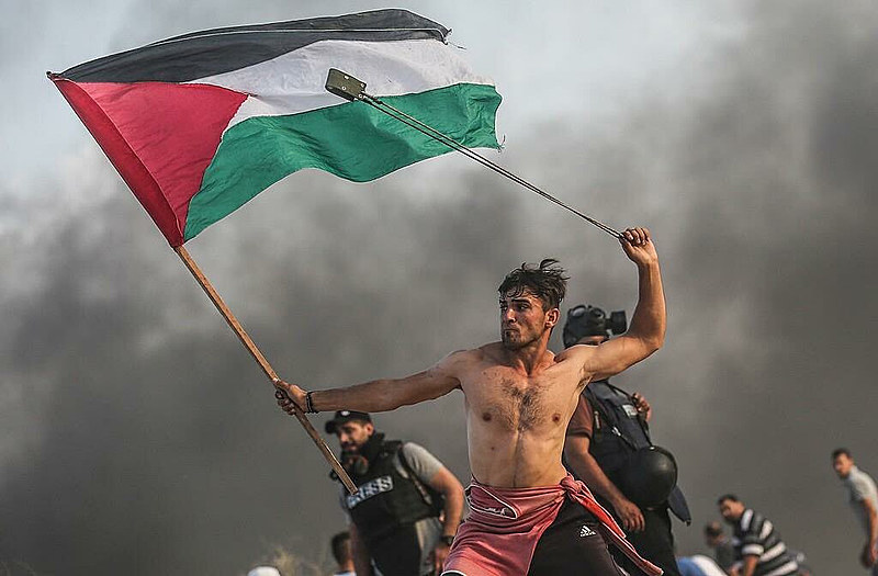 Homem empunha bandeira palestina em cidade ao norte de Gaza