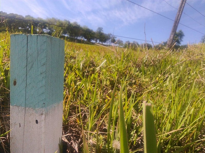 Da estaca se vê o rio, terra e uma casa. No futuro, tudo debaixo d'água represada. Como fica a gente da terra?