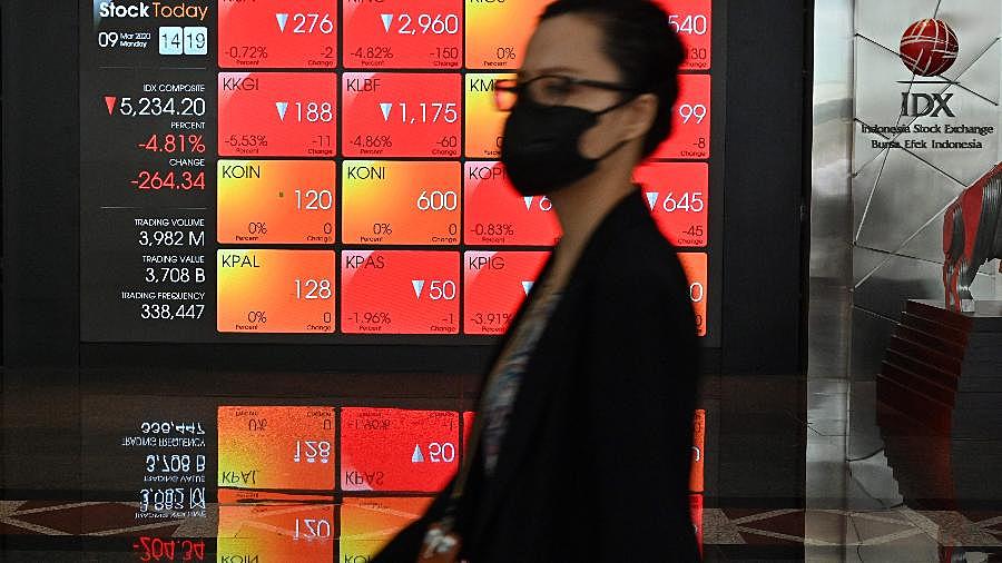 Mulher usa máscara na Bolsa de Valores da Indonésia, em Jacarta, no dia de caos nos mercados mundiais