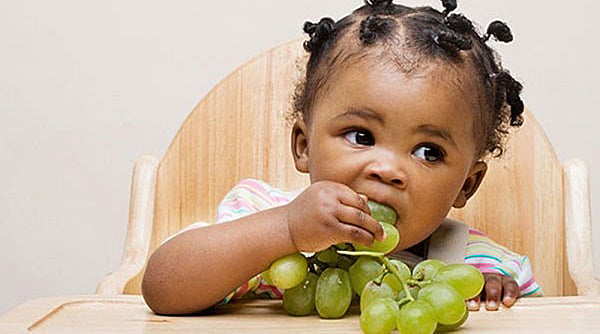 criança comendo uvas