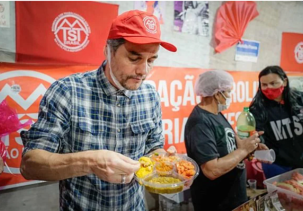 Wagner Moura comendo marmita com camarão seco em ocupação do MTST