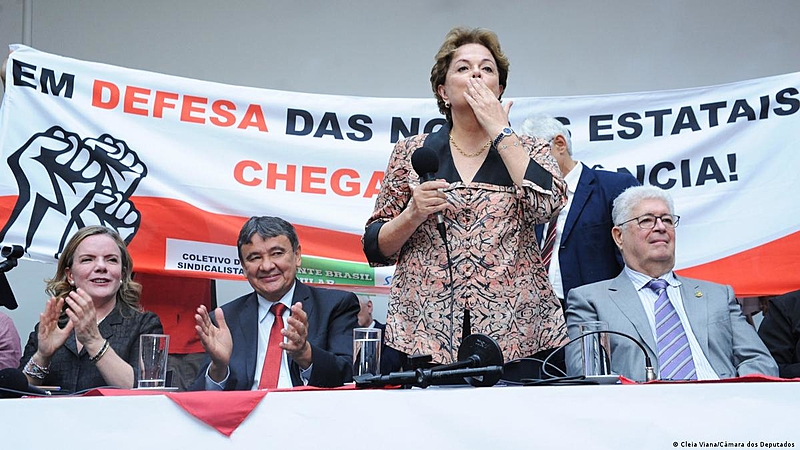 Dilma Rousseff (em pé) durante evento político com correligionários; petista foi deposta em maio de 2016