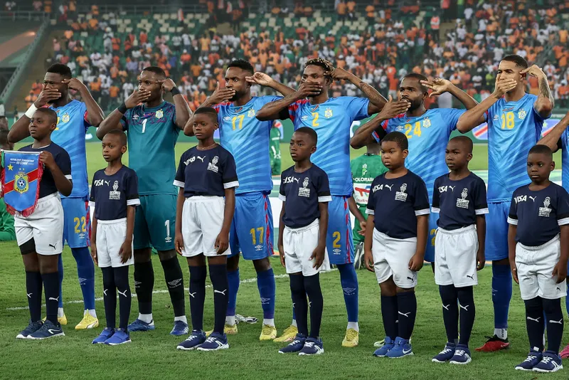 Jogadores da República Democrática do Congo protestam antes de jogo da Copa Africana contra o silêncio da mídia internacional sobre os massacres que ocorrem no leste do país
