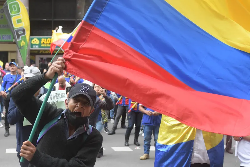 homem segura bandeira da colômbia